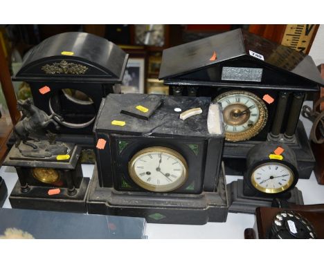 FOUR VARIOUS LATE 19TH/EARLY 20TH CENTURY BLACK SLATE AND PAINTED METAL MANTEL CLOCKS, and an empty clock case, some restorat