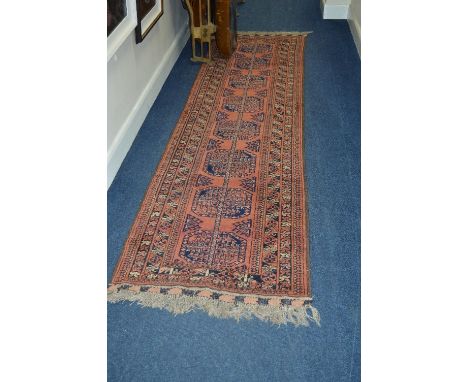 A 20TH CENTURY AFGHAN CARPET RUNNER, russet ground, multi strap border and central geometric motifs, approximate size 298cm x