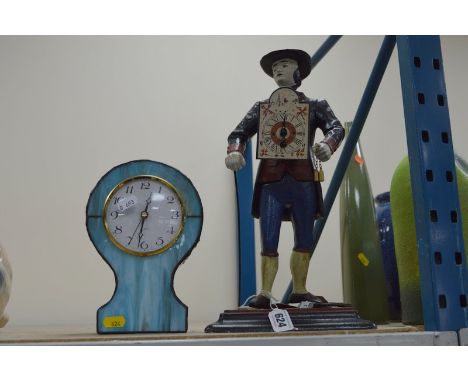 A 20TH CENTURY CAST AND PAINTED METAL PEDLAR CLOCK, mounted on a painted metal base, approximate height 39cm, together with a