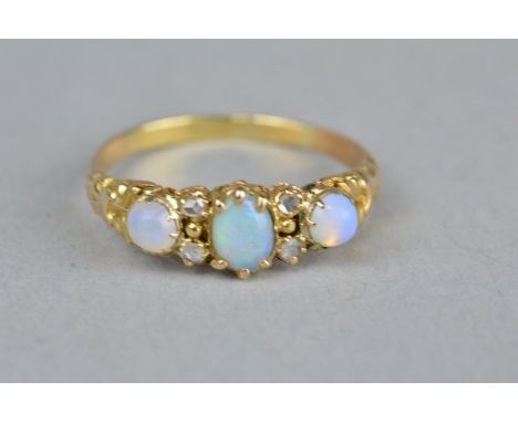 A VICTORIAN PRECIOUS OPAL AND DIAMOND YELLOW GOLD (UNMARKED) RING, (assessed as 18ct gold), three cabochon cut opals with fou