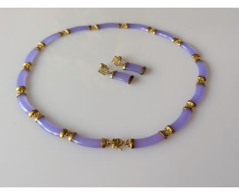 A dyed purple jade panel necklace, with 15 curbed panels and gold coloured chain links between and box clasp with matching ea