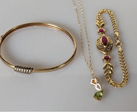 A yellow gold bangle with applied decoration, 60mm and a peridot pendant chain, both 9ct, 8.15g and a gem-set yellow gold bra