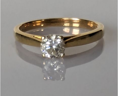 A solitaire diamond ring on a yellow gold claw setting, the round brilliant cut diamond approximately 0.40 carats, hallmarked