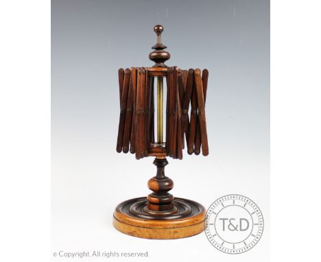 A 19th century lignum vitae wool winder, designed with four concertina arms with a turned finial and circular base, 33cm high