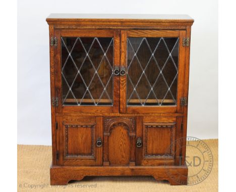 An oak Old Charm type bookcase, with two glazed doors and two cupboard doors, on bracket feet, 103cm H x 84cm W x 26cm D
