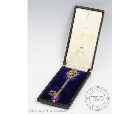 A silver gilt and enamel presentation key, Fattorini &amp; Sons, Birmingham 1909, terminal with enamelled coat of arms and in