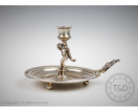 A continental silver chamber stick, possibly Austrian, stamped '800', designed as a cherub supporting a candle holder on a ci
