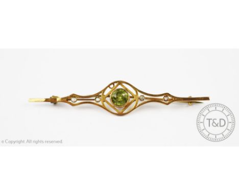A peridot and seed pearl set brooch, the central peridot within circular surround and with seed pearl set bar, all set in yel