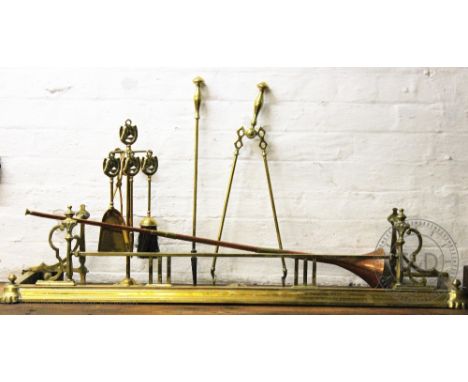 A brass fender, with a selection of fire tools and a copper coaching horn