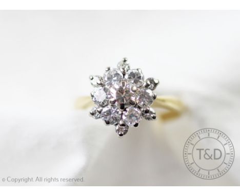 A diamond cluster ring of snowflake form, designed as a central diamond within a surround of six diamonds, and a further surr