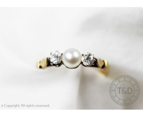 A pearl and diamond three stone ring, designed as a central untested pearl flanked by two old brilliant cut diamonds, all set