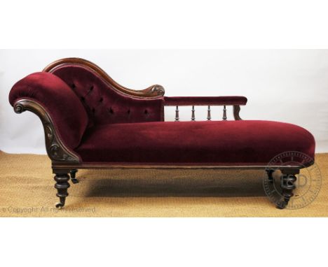 A Victorian carved walnut chaise longue, with button back red upholstery and scroll frame, on turned legs, 88cm H x 190cm W
