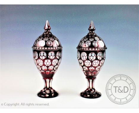 A pair of late 19th century Bohemian ruby flashed glass vases and covers, of ovoid form,33.5cm high (chip to the tip of finia