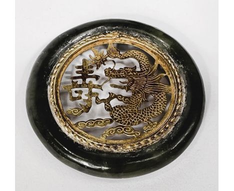 A Chinese nephrite jade disk with gilt dragon decoration to the centre, diameter 6cm