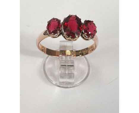 A 9ct hallmarked gold dress ring set with 3 oval red faceted stones, size O, 1.2gm 