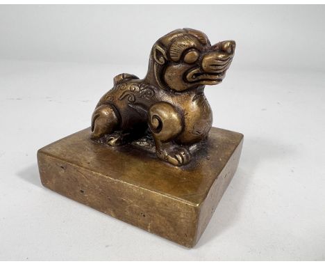 A heavy Chinese brass seal in the form of a Dog of Fo on rectangular base, length 8.5cm 