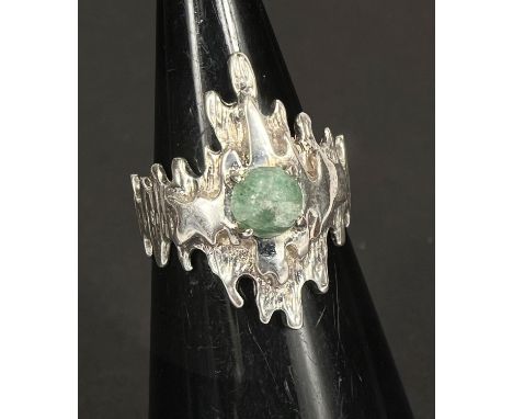 A hallmarked silver 'Brutalist' bark effect dress ring set with circular cabochon green stone, 5.6gm, size N 