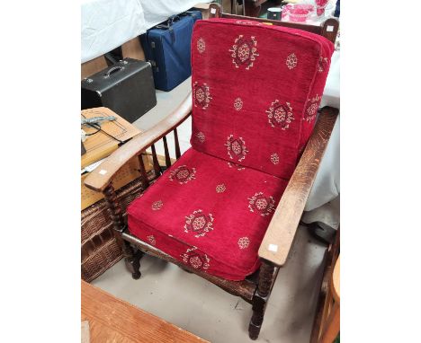 A 1930's oak armchair with collapsible back rest, bobbin turned supports 