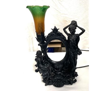 A bronzed table lamp decorated with girls, with coloured shade and mirror back 