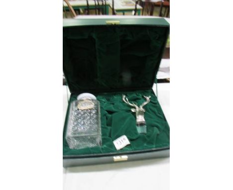 A cased Glenfiddich whisky decanter with stag head stopper and silver lable (no contents)