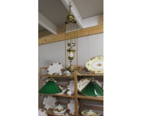 A brass art nouveau twin arm rise and fall ceiling light with green and white glass shades. 