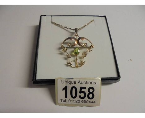 An Edwardian peridot and pearl set brooch/pendant in rose gold, stamped 9ct. 