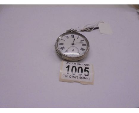 A silver pocket watch with key. 