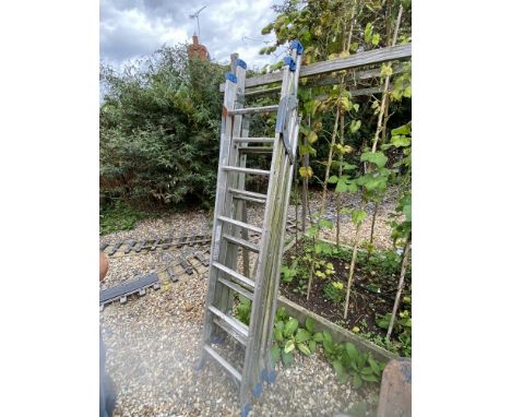 A heavy duty industrial triple ladder with adjustable feet and stays.