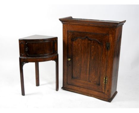 An early 19th century oak straight front wall cupboard with moulded cornice above an ogee arched top inset cupboard door encl