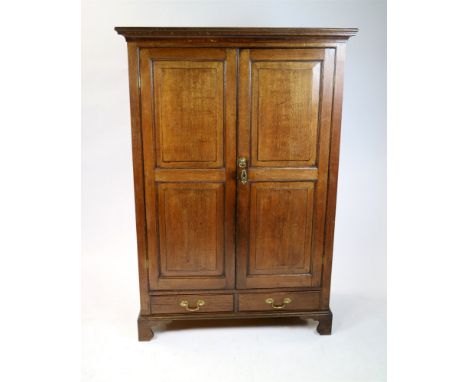 A 19th century oak free standing hanging wardrobe, the ogive cornice above two fielded panel doors enclosing hanging poles ab