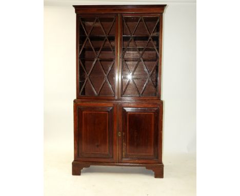 A mahogany and box wood strung book case, 19th century, the moulded cornice above two lattice ribbed doors enclosing adjustab