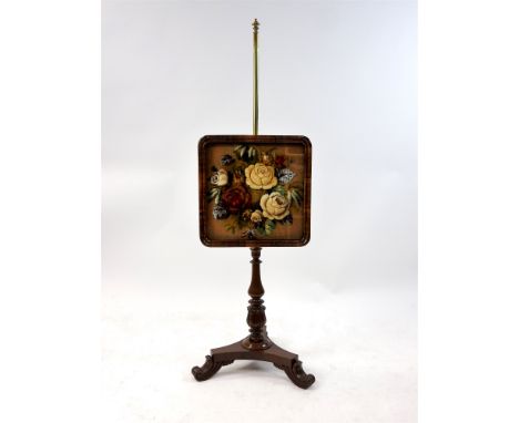 An early Victorian rosewood and mahogany pole screen with brass column and glazed panel enclosing a raised wool work tapestry