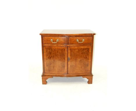 A Bevan Funnell Reprodux crossbanded figured walnut side cabinet in George III style, the serpentine front with two cockbeade