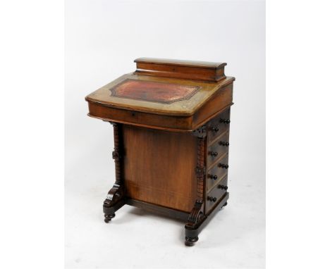 A Victorian walnut and inlaid davenport with lift top stationary compartment above an inset gilt tooled leather writing slope