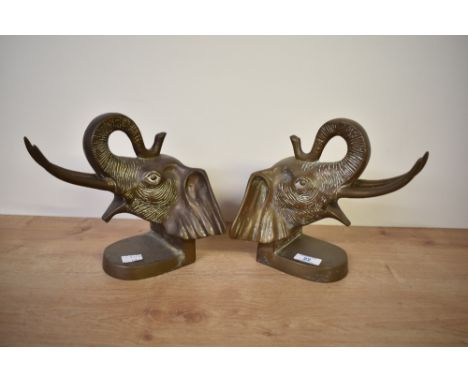 A pair of cast brass elephant head bookends each having trunk up forming a loop, h21cm