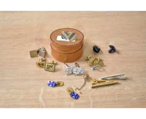 A circular leather lidded stud pouch containing various men's cufflinks and tie clips, w6.5cm
