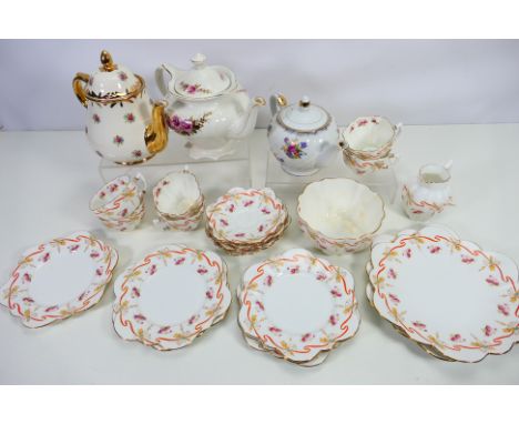 A collection of Paragon China tea wares decorated with pink flowers and red ribbons, twenty two pieces and three teapots to i