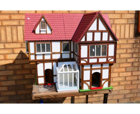 Dolls House - A large wooden Tudor style dolls house with hinged opening roof and removable wall sections. It measures 73 x 6