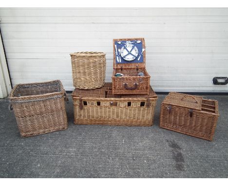 A collection of wicker baskets. Baskets included are 2 picnic style baskets, one with a picnic set included. A large trunk ba