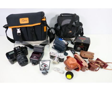 A collection of cameras to include; a Halina in case, a Canon EOS 650 in carry case, a JVC digital video camera and a Miranda