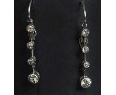 A pair of gold diamond drop earrings, with a line of three old brilliant cut diamonds terminating in a larger old European cu