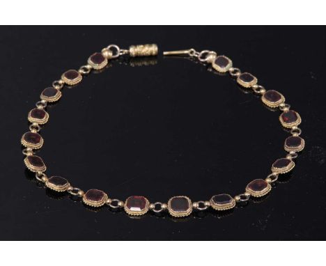 A gold garnet set graduated rivière necklace, possibly c.1880, with a series of graduated octagonal step cut garnets, each on