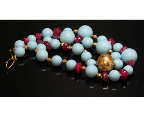 A single row reconstituted turquoise, ruby and gold bead necklace,with a series of graduated reconstituted turquoise beads, 1