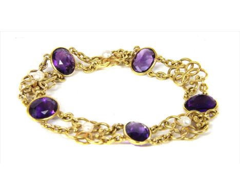 An Edwardian gold amethyst and pearl bracelet,oval mixed cut amethysts, spectacle set, alternating with scrolling links, peg 
