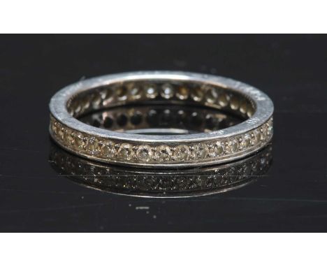 A platinum diamond set full eternity ring by Cartier,with a row of brilliant cut diamonds, grain set to a flat section band, 