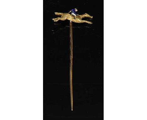 A gold and enamel jockey on horseback stick pin, with a polychrome enamel jockey with a dark blue body and sleeves and yellow