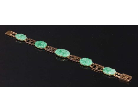 A gold jadeite bracelet, with oval pierced carved jadeite panels, with bird and flower motifs, four claw set to plain collets