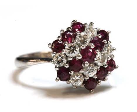 A white gold ruby and diamond hexagonal cluster ring,with alternating rows of circular mixed cut rubies and brilliant cut dia