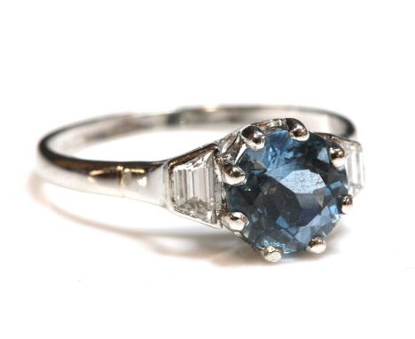 A platinum aquamarine and diamond ring,a circular mixed cut aquamarine, eight claw set to a pierced collet, with a trapezoid 