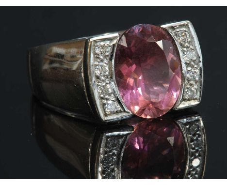 A white gold pink tourmaline and diamond ring,with an oval mixed cut pink tourmaline, with a stated weight of 3.75ct, end set